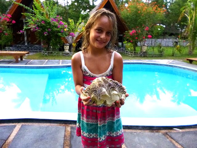 Lilli hält ihren Muschelfund in den Händen